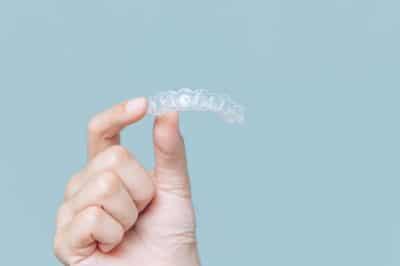 hand holding up Invisalign Clear Braces, Alternative To Orthodontics