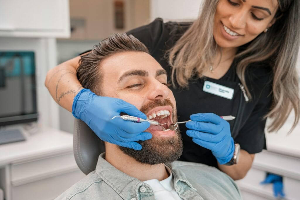 Female dentist in blue gloves performing a dental examination