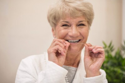Woman smiling while flossing teeth