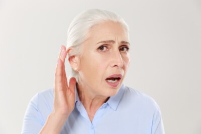 Woman with TMJ pain touching her ear