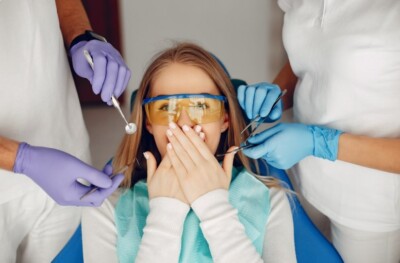 Woman sitting in a dentist's chair, wearing protective glasses