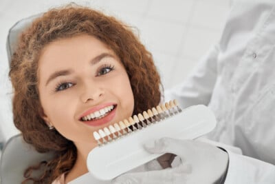 Dentist showing a shade guide to a smiling woman