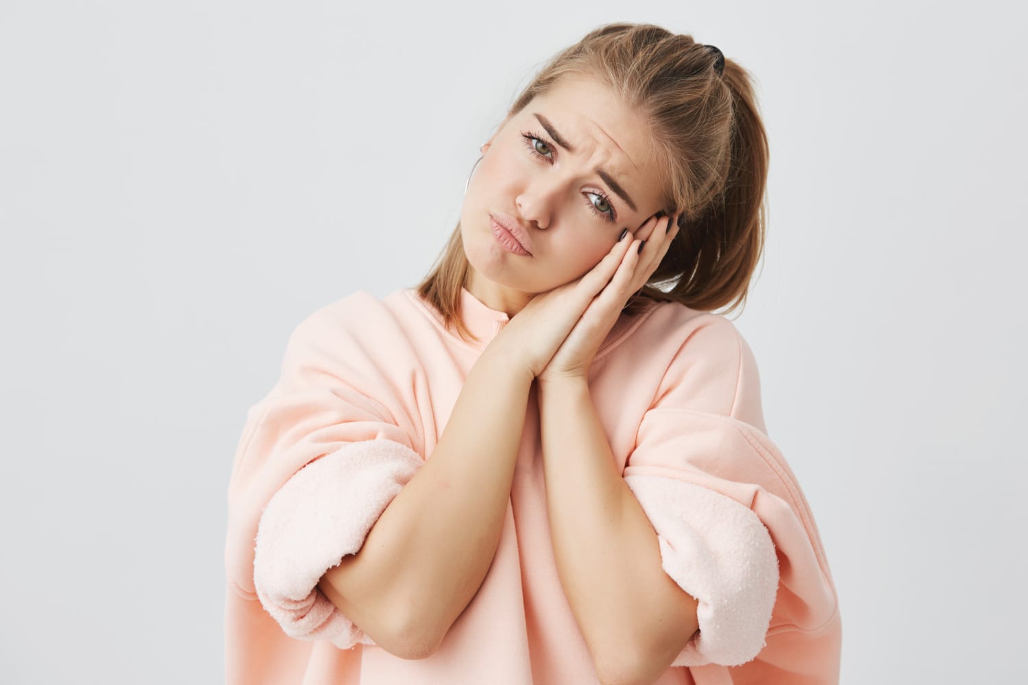 Woman resting her head on her hands with a concerned expression