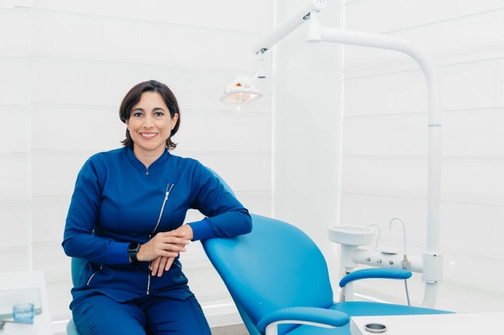 Certified female dentist smiling in a modern dental office